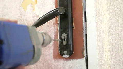 The worker drills the door lock Stock Footage 95009342