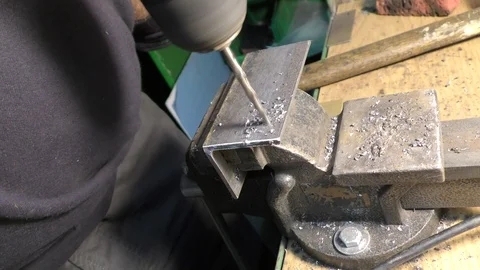 A worker drills a hole with an electric drill. Video stock 118608016