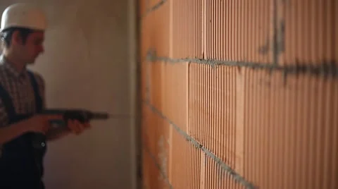 Worker drills hole in wall bokeh Stock Footage 61695732