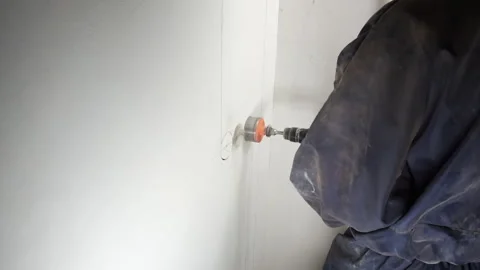 A worker drills a hole in the wall. Stock Footage 260927650