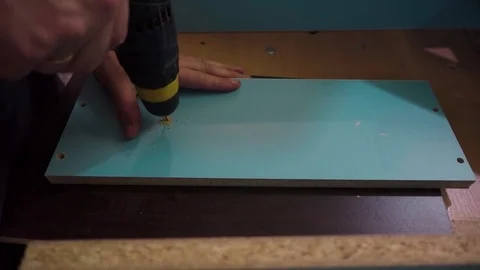 A worker drills holes in a board Stock Footage 76915036