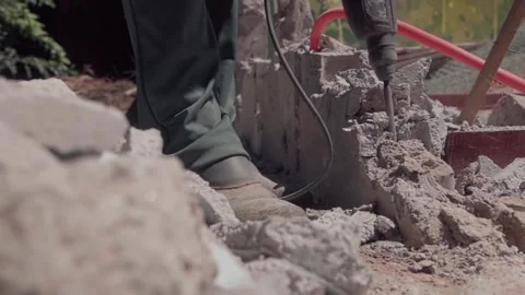 Worker drills through broken concrete during demolition work in slow motion Stock Footage 345080090