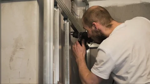 The worker drills the wall and fastens the frame Stock Footage 74793628