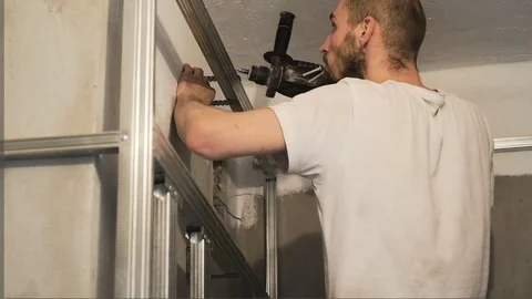 The worker drills the wall and fastens the frame Stock Footage 74798904