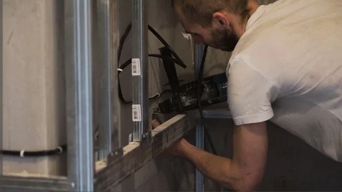 The worker drills the wall and fastens the frame Stock Footage 74801474