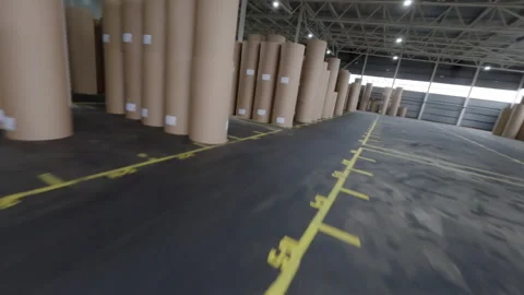 Worker drives forklift loader in paper plant storage FPV Stock Footage 291336793