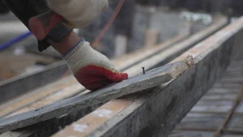 Worker drives nail through aged wooden boards in workshop Stock Footage 313832118