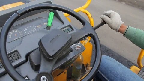 A worker drives a road roller for laying asphalt Stock Footage 75646854