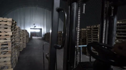 Worker is driving the elecric forklift. Loader and wooden pallet with boxes when Stock Footage 163434296
