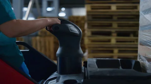 Worker driving warehouse machine transporting export supply pallets managing Video stock 169891065
