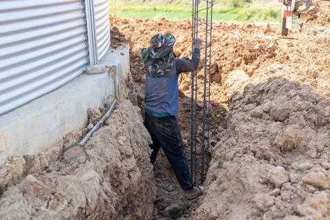 Worker drop steel bar structure to pit of pile. Stock Photos