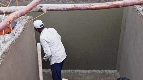 Worker dropping cement water on wall for final Plastering at lower water Stock Footage 327339871