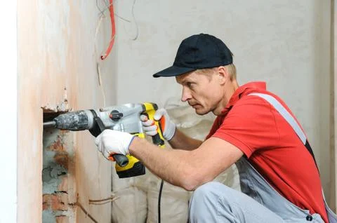 Worker with an electric hammer. Stock Photos