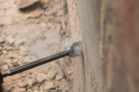 Worker with electrical hammer cleaning red brick wall outdoor Stock Photos