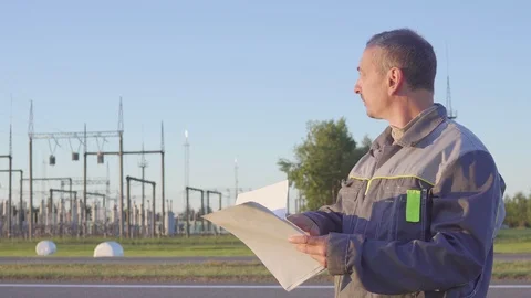 Worker at Electrical Substation. Worker with blueprints and clipboard in meeting Video stock 90464385