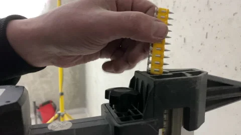 Worker electrician loading gun nailer closeup construction site moving shot Stock Footage 150175391