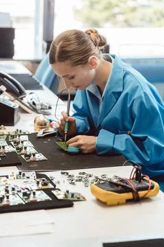 Worker in electronics manufacturing soldering a component Stock Photos