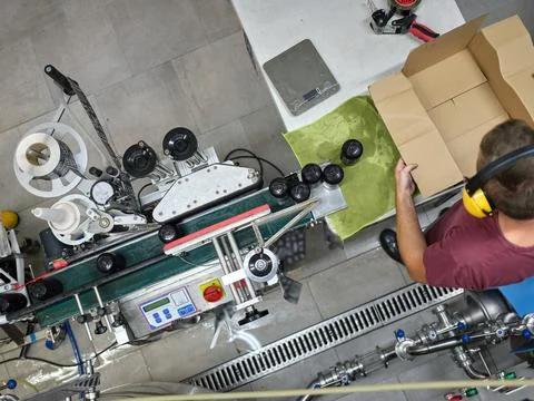 Worker at the end of a production line packing cans of beer to ship in a brewery Stock Photos