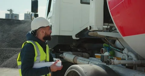 A worker engineer supervises the operation of trucks at a cement plant. Stock Footage 277595713