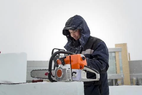 Worker examines the condition of the chainsaw Foto stock