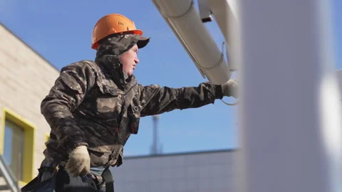 Worker examines drainpipe brackets on porch framework Видео 306416106