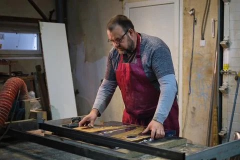 Worker examines joinery; precision, expertise. It underscores the value of Stock Photos