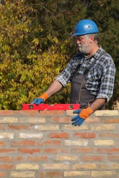 Worker examining brick wall Stock-Fotos