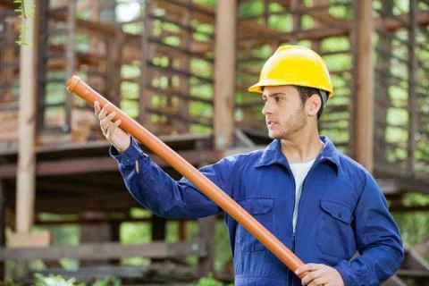 Worker Examining Pipe At Construction Site Stock Photos