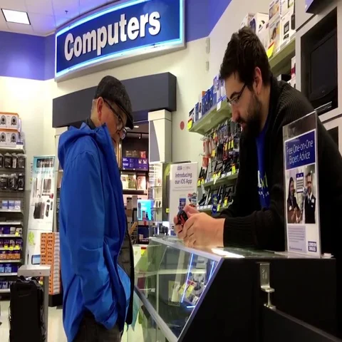 Worker explaining camera function for customer inside London drugs store. 스톡 동영상 69700972