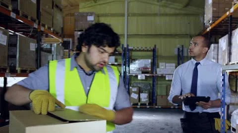 Worker in a factory is approached by his manager Stock Footage