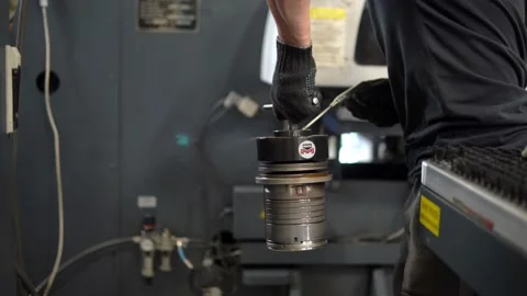 The worker at the factory blowing it off with air under pressure a metal part Stock Footage 201820734