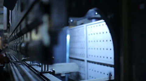 Worker in factory at metal skip machine putting work piece in. Man working with  Stock Footage 60470667