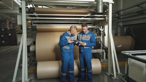 Worker at factory next to machine talks to colleague. Maintenance, programming Stock Footage 280789801
