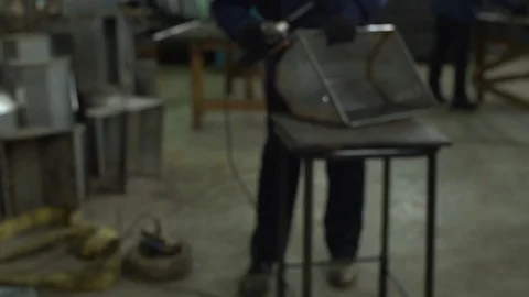 A worker at the factory processes with the angle grinder feeders for pig farm Stock Footage 81247455