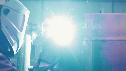 A worker at a factory in a protective mask welds a metal structure. Stock Footage 306540292