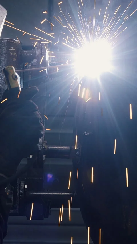 A worker at a factory in a protective mask welds a metal structure. Stock Footage 306659938