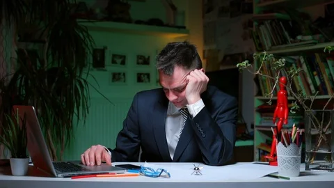 The worker falls asleep at work, his head falls down. Stock Footage 128100054