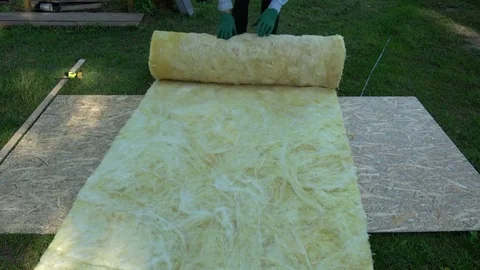 Worker in farm roll rockwool insulating material for cutting 스톡 동영상 76506962