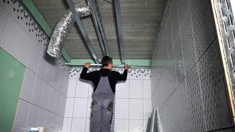 Worker fasten ceiling profiles in new flat room Stock Footage 109503442