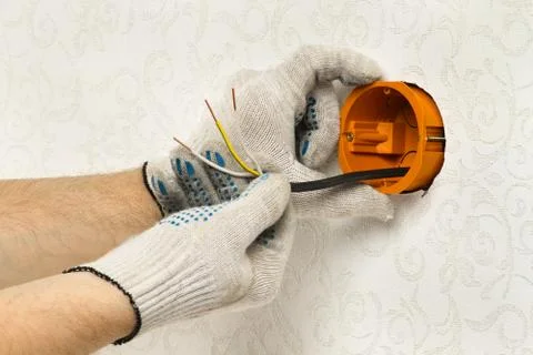 Worker fastens the socket box Stock Photos