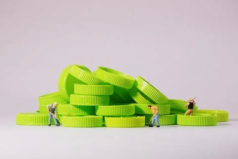 Worker figure standing on plastic cap. Recycle material concept. Stock Photos