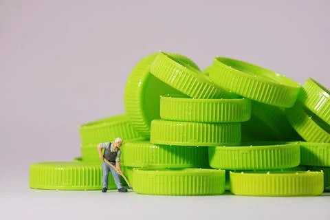 Worker figure standing on plastic cap. Recycle material concept. Stock Photos