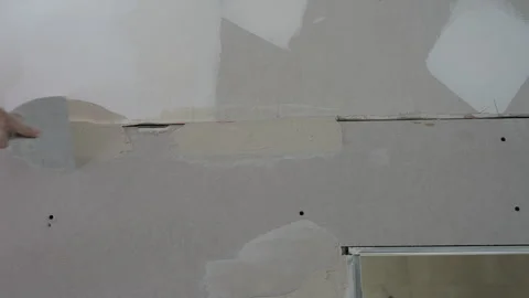 Worker filling joint between drywall panels with plaster during apartment Vídeos de archivo 319647945