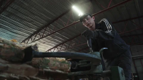 Worker is fixating the processed wooden log with holding equipment at a factory Stock Footage 171970912