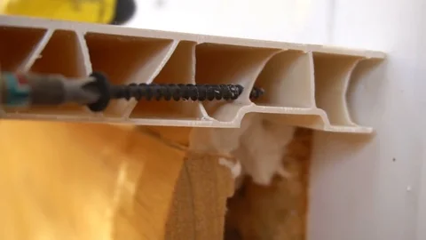 A worker fixes installed window sill using the screws Stock Footage 77830213