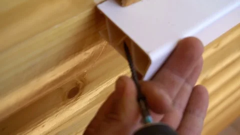 A worker fixes installed window sill using the screws Stock Footage 77830576