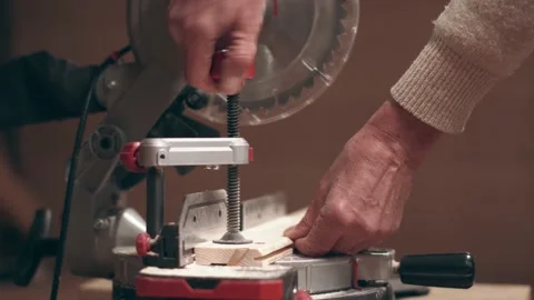 A worker fixes a wooden board in a sawing machine and cuts it into several Stock Footage 201683499