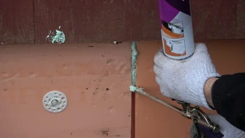 Worker  with fixfoam glue fixing slots of polystyrene Stock Footage 82888727