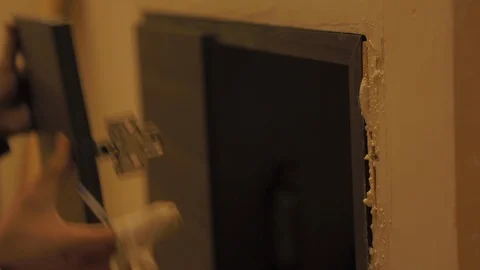 Worker fixing and installing the wooden frame of a door with a hammer in Stock Footage 110771572