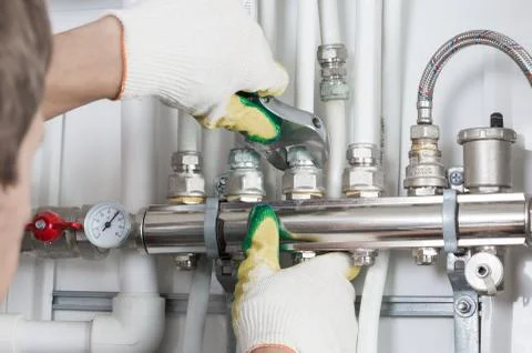 Worker fixing heating system, close up photo Stock Photos